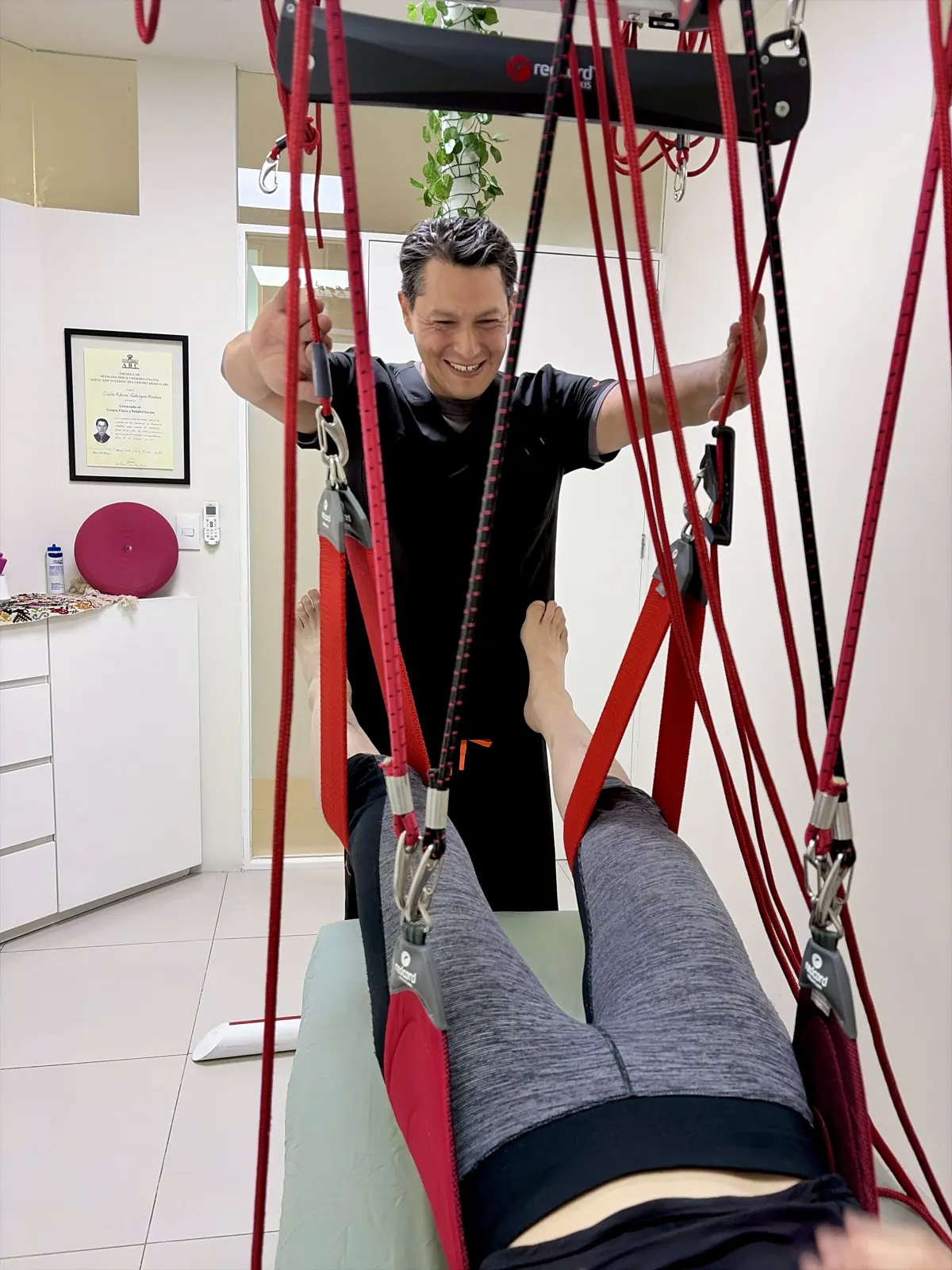 Terapeuta de Reactivarte guiando un ejercicio con el sistema Redcord